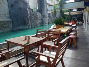 un ristorante con tavoli e sedie in legno accanto a un fiume di rastahostel by little boat a Chaweng Beach