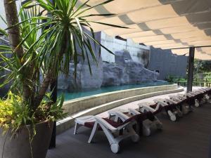 a row of lounge chairs in front of a swimming pool at rastahostel by little boat in Chaweng