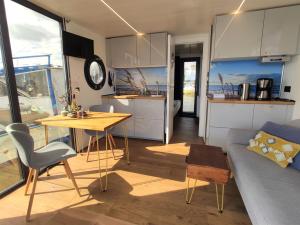 cocina y sala de estar con mesa y sofá en Hausboot Hilja - neuer Ankerplatz!, en Schleswig