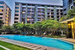 una piscina frente a un edificio en 沙吞Blossom Sathon精品公寓 en Bangkok