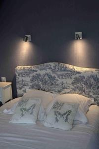 a bed with white pillows and a blue and white wall at Villa les Dunes in Saint-Jean-le-Thomas