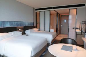 Habitación de hotel con 2 camas y mesa en Guangzhou Marriott Hotel Nansha, en Guangzhou