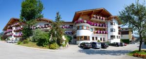 un grande edificio con auto parcheggiate di fronte di Ferienhotel Fuchs a Söll