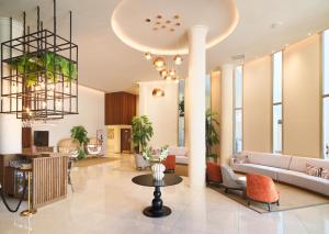 a lobby with a couch and chairs and a table at Leonardo Boutique Hotel Larnaca in Larnaca