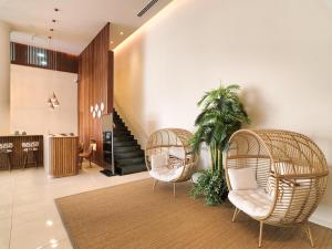 a lobby with two wicker chairs and a staircase at Leonardo Boutique Hotel Larnaca in Larnaca