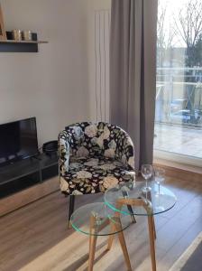ein Wohnzimmer mit einem Stuhl und einem Glastisch in der Unterkunft Gościniec Mazurek , Apartament przy Jeziorze Niegocin in Wilkasy