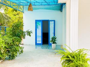 a blue door on a white house with plants at Ben's House 2 in Quy Thượng