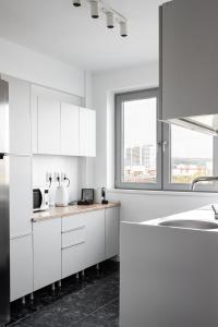 クルジュ・ナポカにあるSpacious ultracentral apartmentの白いキッチン(白いキャビネット、シンク付)