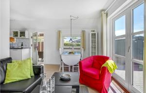 een woonkamer met een rode stoel en een tafel bij 2 Bedroom Amazing Home In Otterup in Otterup