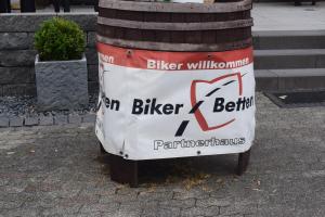 a barrel with a sign on it sitting on the street at Alte Dorfschänke in Kinderbeuern