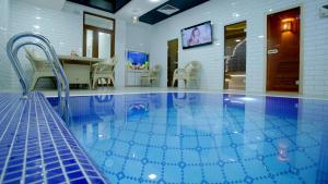 a large swimming pool with chairs and a table at VELARA HOTEL in Tashkent