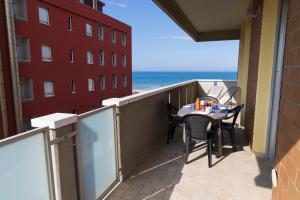 uma varanda com uma mesa e cadeiras e o oceano em Nadì Home con vista mare a Pesaro by Yohome em Pesaro