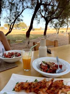 una mesa con dos platos de comida y una bebida en Studio at beautiful beach Kouremenos, en Anevató