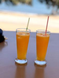 dos vasos de zumo de naranja sentados en una mesa en Studio at beautiful beach Kouremenos, en Anevató