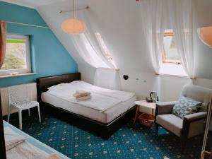 een kleine slaapkamer met een bed en een stoel bij Apartamenty Beata w Sasinie in Sasino