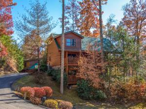 a log cabin in the woods with a driveway at Cub’s Corner, 3 Bedrooms, Pool Access, Hot Tub, Pool Table, Sleeps 10 in Gatlinburg