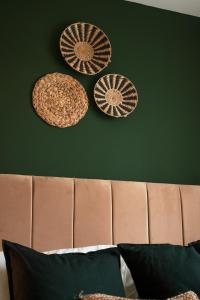 drei Platten hängen an einer grünen Wand über einem Bett in der Unterkunft Kandaka-Specious Stylish Home - Suitable for Contractors in Killingbeck