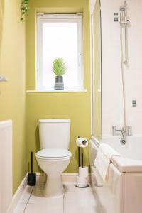 ein Bad mit WC und ein Fenster mit Topfpflanze in der Unterkunft Kandaka-Specious Stylish Home - Suitable for Contractors in Killingbeck