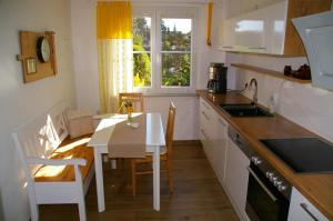 a kitchen with a small table and a table and chairs at Ferienhaus Hummel-Nest in Laußnitz