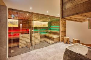 a bathroom with wooden walls and a glass wall at Pension Widderstein in Lech am Arlberg