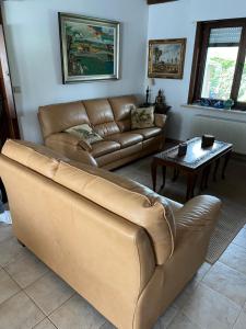 a living room with a leather couch and a table at Villa Jean in Blankenberge