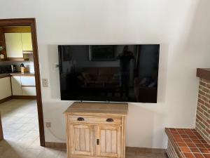 TV de pantalla plana grande en la pared de la sala de estar. en Villa Jean en Blankenberge