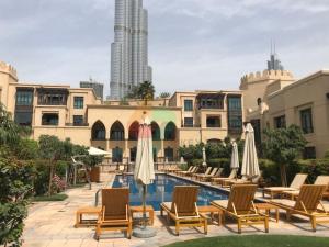 une piscine sur le toit d'un immeuble avec des chaises et des parasols dans l'établissement Al Tajer, Core C, Souk Al Bahar - Vacationer, à Dubaï