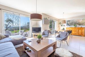 a living room with a couch and a table at Villa proche Annecy in Lovagny