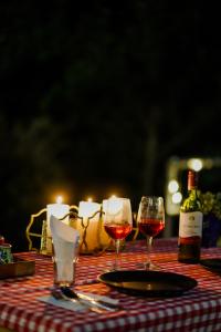 a table with two glasses of wine and candles at Shivoham Himalayan Resort in Almora