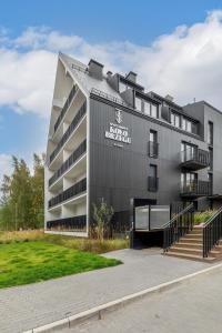 a building with a sign on the side of it at Apartamenty KOŁO BRZEGU Sauna i Jacuzzi Kołobrzeg by Renters in Kołobrzeg