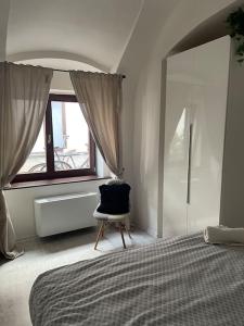 - une chambre avec un lit, une chaise et une fenêtre dans l'établissement MiMa, à Košice