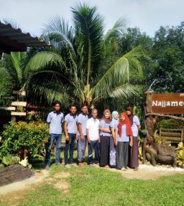 a group of people standing in front of a sign at Najjamee Bungalows in Ko Yao Noi