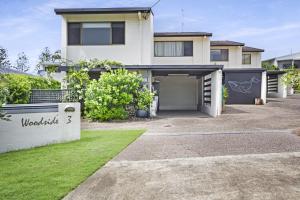 a white house with a garage in a yard at Woodside Townhouse Peregian Beach in Peregian Beach