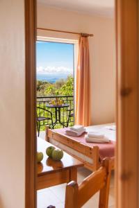 a room with a bed and a view of a balcony at Amarandos Studios with swimming pool by Imagine Lefkada in Tsoukaladhes