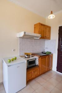 a kitchen with a stove and a white refrigerator at Amarandos Studios with swimming pool by Imagine Lefkada in Tsoukaladhes