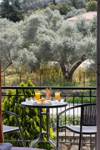 uma mesa numa varanda com vista para uma árvore em Amarandos Studios with swimming pool by Imagine Lefkada em Tsoukaladhes