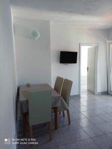 a dining room with a table and chairs and a television at Boni02 in Gdinj