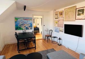 Stege Torv Family Apartment في شتايغ: غرفة معيشة مع طاولة وتلفزيون بشاشة مسطحة
