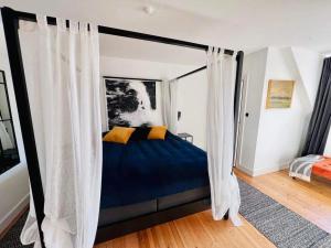 a bedroom with a canopy bed with curtains at Stege Torv Family Apartment in Stege