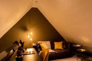 una sala de estar con un sofá marrón en el ático en Bed en breakfast Suite 8 en Langenboom