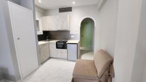 uma pequena cozinha com um sofá e um fogão em Corfu Paloma Apartments em Ýpsos