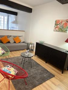 a living room with a couch and a table at EGLANTINE 14 APPARTEMENT CENTRE HISTORIQUE DE DINAN in Dinan