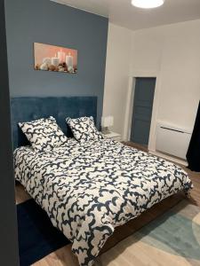 una camera da letto con un letto con un piumone bianco e nero di EGLANTINE 14 APPARTEMENT CENTRE HISTORIQUE DE DINAN a Dinan