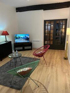 a living room with two chairs and a television at EGLANTINE 14 APPARTEMENT CENTRE HISTORIQUE DE DINAN in Dinan