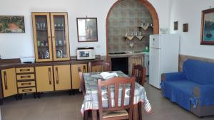 a kitchen and living room with a table and a blue couch at Marina di Mancaversa Dolce Salento in Taviano