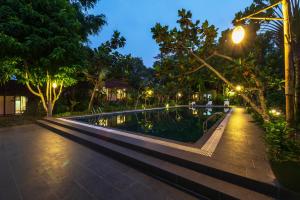 una luz de la calle junto a una piscina por la noche en An Nhien Retreat, en Phu Quoc
