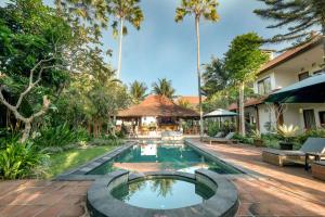 an image of a pool at a resort with palm trees at Artini Bisma Ubud Hotel in Ubud