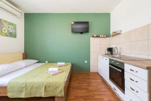 a small room with a bed and a kitchen at Studio and Rooms Zadar City Wall in Zadar