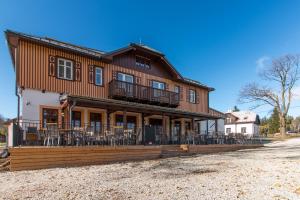 a house with tables and chairs in front of it at Hotel Franz in Rejvíz