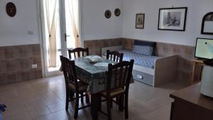 un soggiorno con tavolo, sedie e divano di Marina di Mancaversa Dolce Salento a Taviano